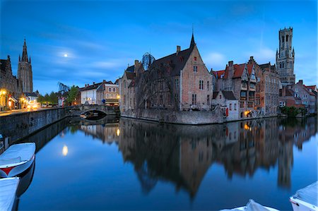 The medieval Belfry and historic buildings are reflected in Rozenhoedkaai canal at dusk Bruges West Flanders Belgium Europe Stock Photo - Rights-Managed, Code: 879-09021231