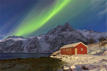 Northern Lights illuminate snowy peaks and the wooden cabin on a starry night at Budalen Svolvaer Lofoten Islands Norway Europe Stock Photo - Rights-Managed, Code: 879-09034170