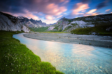 Clouds are reflected in the stream during a windy sunrise. Unterer Segnesboden, Flims, District of Imboden, Canton of Grisons, Switzerland, Europe Stock Photo - Rights-Managed, Code: 879-09189708