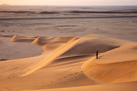 swakopmund - Man looks at the vastness of the desert while the sun is rising,Walvis Bay,Namibia,Africa Stock Photo - Rights-Managed, Code: 879-09189749