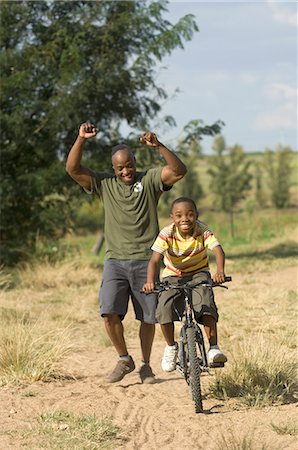 Father Helping Son Ride Bike Stock Photo - Rights-Managed, Code: 873-06441214