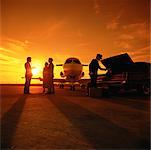 Business People Beside Airplane At Sunset