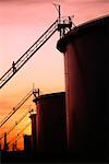 Silhouette of Oil Storage Tanks At Sunset