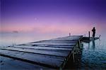 Silhouette of Person Standing on Bretona Pond Pier at Dusk Near Edmonton, Alberta, Canada