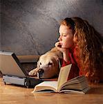 Girl at Laptop Computer with Book And Dog