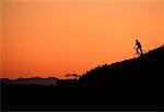 Silhouette de la personne à vélo au coucher du soleil