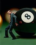 Businessman Struggling to Move Giant Eight Ball