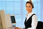 Portrait de femme d'affaires assis devant un ordinateur, à l'aide du casque téléphonique