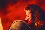 Girl Looking at Globe, Resting Head on Hand