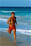 Man in Swimwear, Jogging in Surf On Beach Miami, Florida, USA
