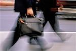 Blurred View of Businessmen Walking Outdoors with Briefcase