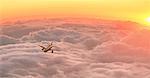 Flugzeug im Flug über Wolken bei Sonnenuntergang