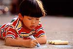 Boy Drawing on Ground with Chalk
