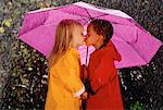 Garçon et fille, le baiser sous le parapluie