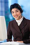 Portrait of Businesswoman at Computer, Using Telephone Headset