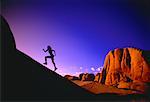 Silhouette of Woman Running Up Hill