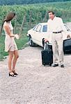 Couple sur le bord de route avec la voiture et valise