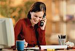 Businesswoman Sitting at Desk Using Phone