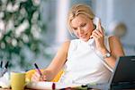Businesswoman Sitting at Desk Using Phone, Writing in Journal