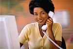 Portrait of Businesswoman Sitting At Computer, Using Phone