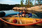 Couple Sitting on Rock with Canoe Temagami, Ontario, Canada