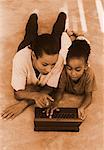 Mother and Daughter Lying on Floor, Using Laptop Computer