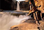 Hiker Sitting near Waterfall Crescent Falls, Alberta, Canada