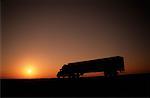 Silhouette des Transport-LKW auf der Straße bei Sonnenuntergang, Trans Canada Highway, Alberta, Kanada