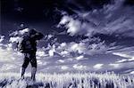 Back View of Hiker Standing in Field, Alberta, Canada