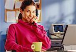 Woman Using Telephone and Laptop Computer