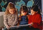 Drei Mädchen lesen im Klassenzimmer