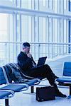 Geschäftsmann mit Laptop-Computer am Flughafen