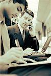 Businessman Using Cell Phone and Laptop Computer