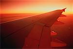 Ansicht des Flügels von Flugzeug bei Sonnenuntergang