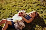 Girl and Dog Lying in Field