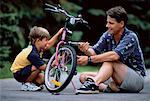 Father and Son Fixing Bicycle Outdoors