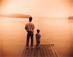 Back View of Father and Son Fishing from Dock