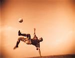 Soccer Player Jumping to Kick Ball