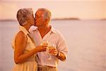 Mature Couple baiser sur la plage de boissons