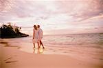 Couple marchant dans le Surf sur la plage