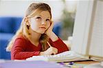 Girl Using Computer, Resting Head on Hand