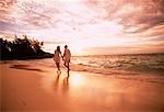 Vue arrière du Couple marchant sur la plage, main dans la main