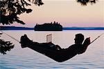 Man in Hammock Using Laptop Computer Algonquin Park, Ontario, Canada