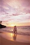 Couple marchant sur la plage au coucher du soleil Bahamas