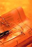 Close-Up of Pen, Eyeglasses and Financial Pages