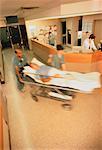 Ansicht der Ärzte verschwommen Wheeling Patienten durch Krankenhaus