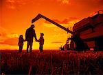 Silhouette of Father with Son and Daughter on Farm at Sunset