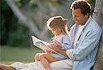 Father and Daughter Reading Outdoors