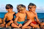 Jungen in Bademode, sitzen am Strand