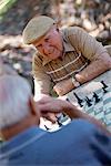 Mature Men Playing Chess Outdoors